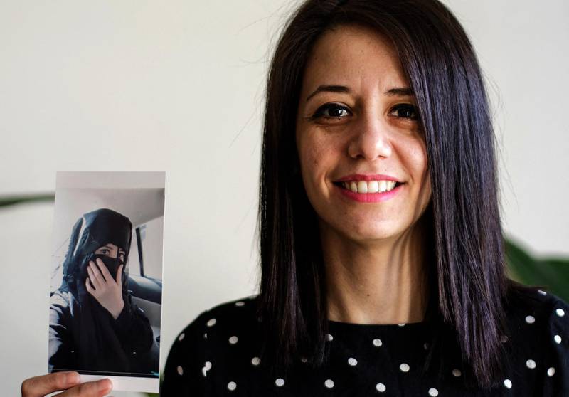 Rukaia Alabadi, 32, a journalist and refugee, poses for a picture in France's capital Paris on February 27, 2021, while holding a photo of herself in 2011 when she was an economics student at Al Furat University in he hometown of Deir Ezzor in eastern Syria. Alabadi arrived in Paris as a refugee in 2018 after escaping threats over her reporting about the reality of life in the eastern province of Deir Ezzor under ISIS. Before that, she had been detained for months over working as a media activist. AFP