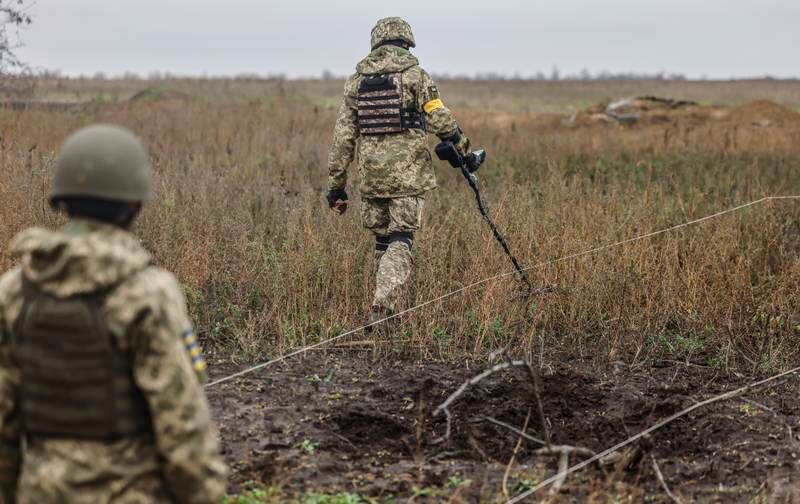 Ukrainian soldiers search for explosives at a recaptured area in the north of Kherson. EPA