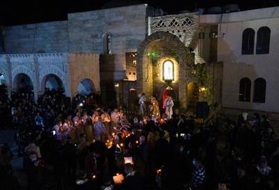 An aerial picture shows Iraqi priests leading the Christmas eve mass at the Syriac Catholic Church of the Immaculate Conception (Al Tahira-l-Kubra), in the predominantly Christian town of Qaraqosh, in Nineveh province, some 30 kilometres from Mosul, on December 24, 2020. (Photo by Zaid AL-OBEIDI / AFP)