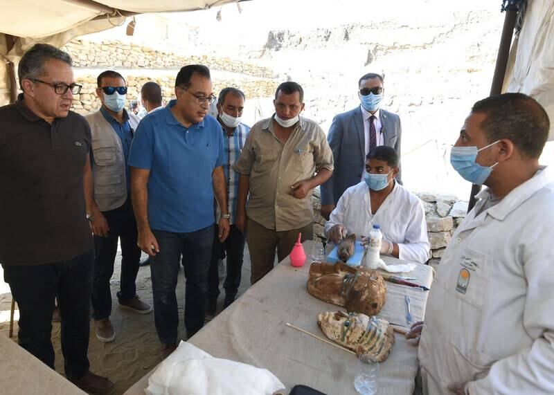 Prime Minister Mostafa Madbouly looks at artefacts from the newly discovered ancient burial shaft. EPA