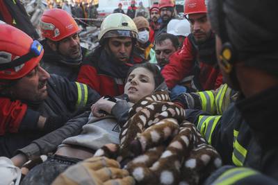 Rescuers carry Muhammed Alkanaas, 12, to an ambulance after five days under the rubble in Antakya, Turkey. AP