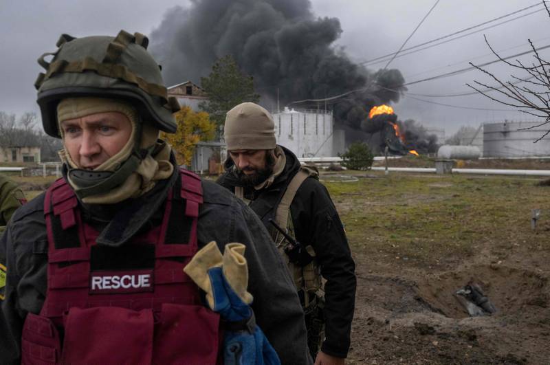 Ukrainian personnel inspect a burning oil plant in Kherson, southern Ukraine. A cap on the price of Russian oil is intended to hit Moscow's funding of the war. AFP