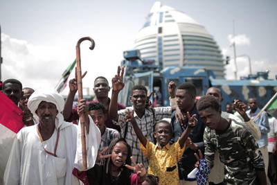 Sudanese people celebrate outside the Friendship Hall in the capital Khartoum where generals and protest leaders signed a historic transitional constitution meant to pave the way for civilian rule in Sudan.  AFP