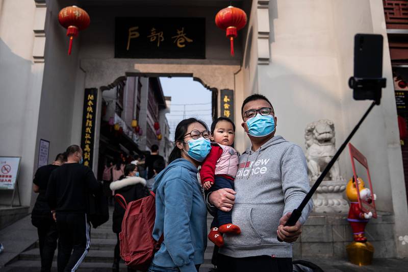 A family take a selfie on a popular street for restaurants during the first day of the Spring Festival in Wuhan, Hubei Province, China. Getty Images