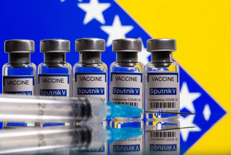 FILE PHOTO: Vials labelled "Sputnik V coronavirus disease (COVID-19) vaccine" and a syringe are seen in front of a displayed Bosnian flag in this illustration picture taken March 17, 2021. REUTERS/Dado Ruvic/Illustration//File Photo