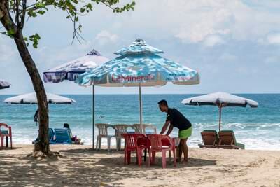 A man disinfects seats for tourists at a beach in Kuta, Bali, Indonesia. EPA