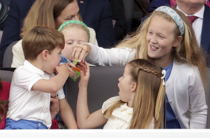 Prince Louis, Princess Charlotte and Savannah Phillips eat sweets during the pageant held outside Buckingham Palace.  AP