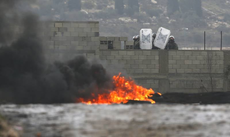 Israeli troops shelter behind shields during confrontations with Palestinian protesters. EPA
