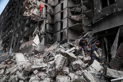 Emergency workers sift through debris of a damaged building in Mariupol. Reuters