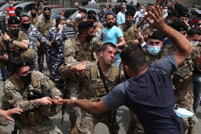 Opponents of Judge Ghada Aoun scuffle with Lebanese soldiers during a sit-in outside the Palace of Justice in Beirut, Lebanon. AP