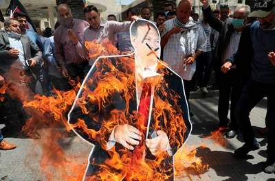 Palestinian men burn a cardboard cutout of US Secretary of State Mike Pompeo during a protest against his visit to Israel in Nablus in the occupied West Bank. AFP