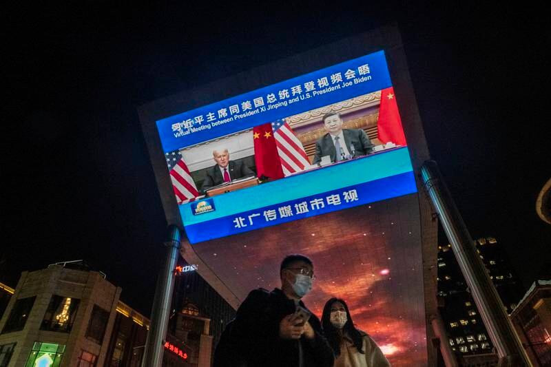 The virtual summit between the presidents, which lasted more than three hours, is displayed on screens in Beijing. Getty