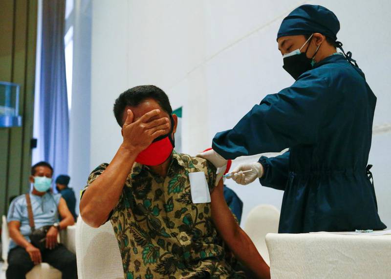 A man reacts as he receives a dose of China's Sinovac Biotech vaccine for the coronavirus disease during the mass vaccination program at a shopping mall in Jakarta, Indonesia. Reuters