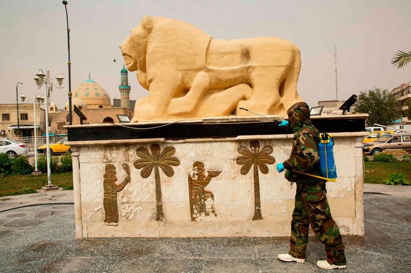 A civil defence worker disinfects a replica of the Lion of Babylon statue in Iraq's southern city of Basra. AFP