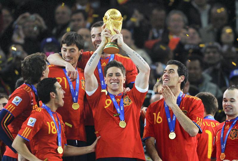 JOHANNESBURG, SOUTH AFRICA - JULY 11:  Fernando Torres of Spain lifts the World Cup trophy as the Spain team celebrate victory following the 2010 FIFA World Cup South Africa Final match between Netherlands and Spain at Soccer City Stadium on July 11, 2010 in Johannesburg, South Africa.  (Photo by Laurence Griffiths/Getty Images)
