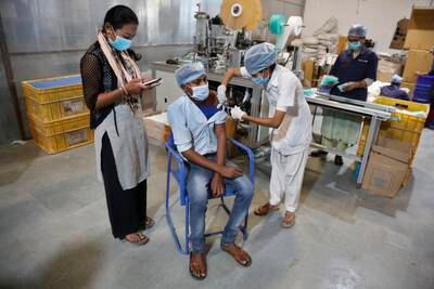 An Indian health worker administers the Covishield vaccine to a worker at the factory of a face-mask manufacturer on the outskirts of Ahmedabad. AP