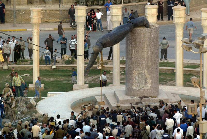 (FILES) In this file photo taken on April 9, 2003 Iraqis watch a statue of Iraqi President Saddam Hussein falling in Baghdad's al-Fardous (paradise) square.
On April 9, 2003, the US-led coalition overthrew Saddam Hussein. Fifteen years after the invasion, life in Iraq has been transformed as sectarian clashes and jihadist attacks have divided families and killed tens of thousands of people, leaving behind wounds that have yet to heal and a lagging economy. / AFP PHOTO / Patrick BAZ