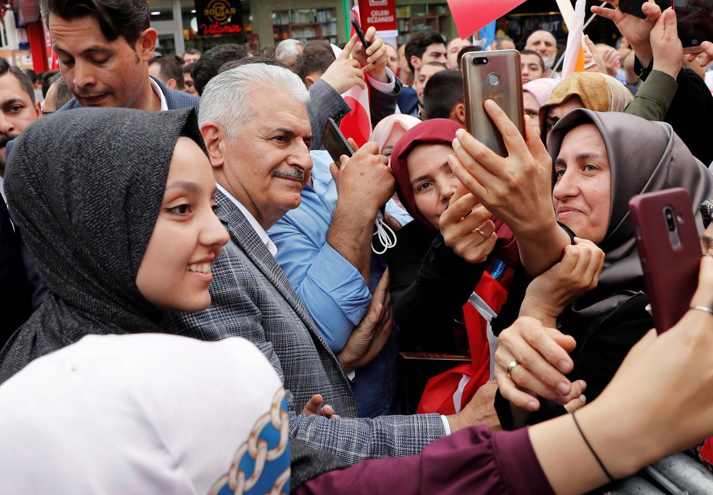 Binali Yildirim, Istanbul mayoral candidate of the ruling AK Party (AKP), poses for a selfie with his supporters during an election rally in Istanbul, Turkey, June 21, 2019. REUTERS/Murad Sezer