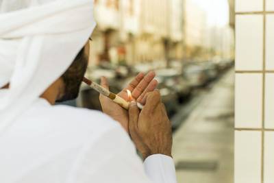 Abu Dhabi, United Arab Emirates, October 4, 2017:    A man smokes dokha from a medwakh pipe in the neighbourhood near the intersection of Delma and Sheikh Rashid Bin Saeed streets in Abu Dhabi on October 4, 2017. On October 1st the government introduced an excise tax on tobacco products and sugar-high drinks, with some prices doubling. Dokha has yet to be added to the list of taxed items though. Christopher Pike / The National

Reporter: Anna Zacharias
Section: News