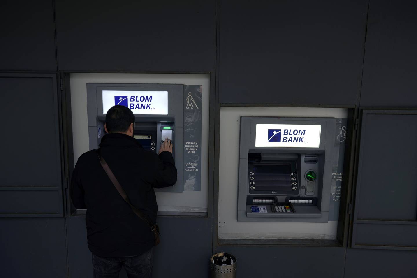 A man uses an ATM outside a closed bank in Beirut. AP