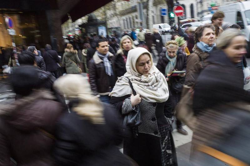 A woman wearing a scarf crosses the street in central Paris. A ruling by the European Court of Justice has reopened the media debate about the hijab. Fred Dufour / AFP Photo