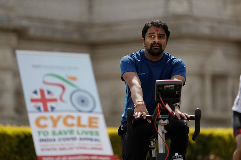 A man takes part in "Cycle to Save Lives" a 48 hour, non-stop static relay cycle challenge at the BAPS Shri Swaminarayan Mandir, also know as the Neasden Temple, the largest Hindu temple in the UK, in north London, to raise money to help coronavirus relief efforts in India. AP Photo
