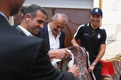 Cristiano Ronaldo, right, is delighted to receive a Persian rug as a gift. EPA