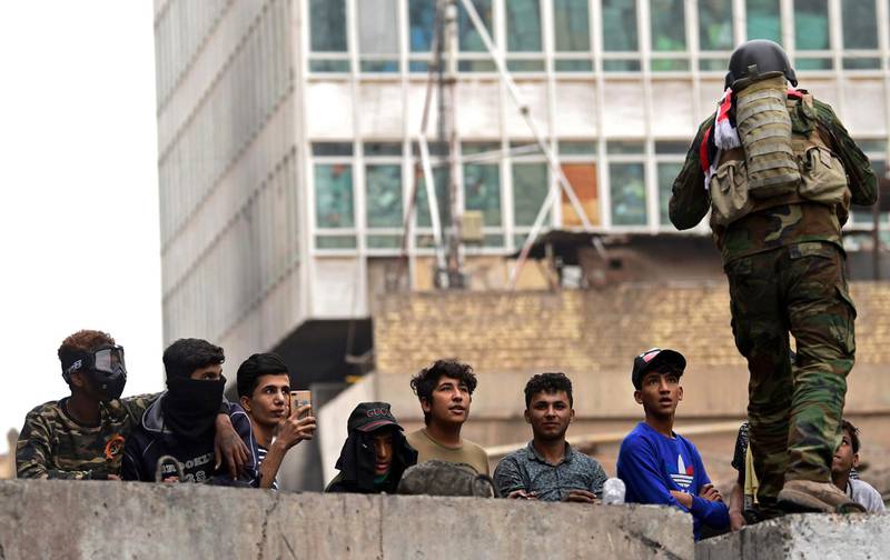 An Iraqi soldier speaks with protesters as they take part in a protest at the Al Rasheed street in central Baghdad.  EPA