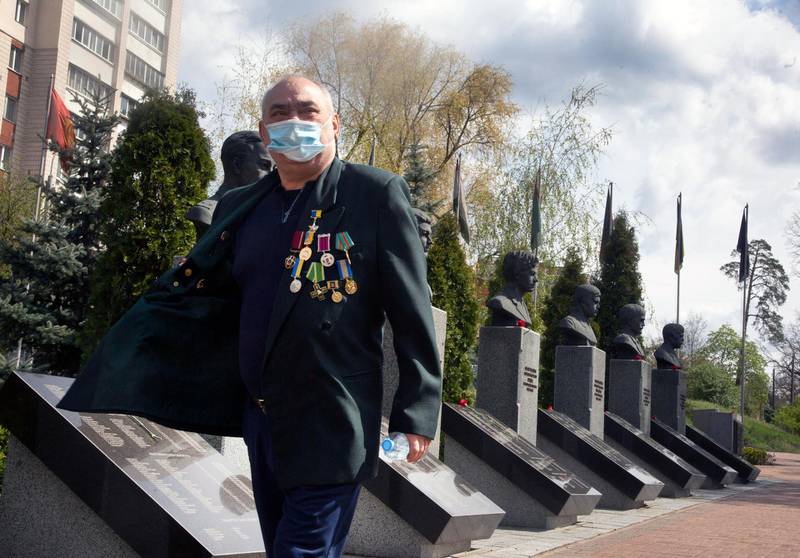A clean-up operation veteran wearing a face mask to protect against coronavirus pays respect to the Chernobyl victims at a memorial in capital Kiev, Ukraine.  AP
