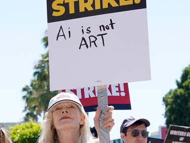 Actor Frances Fisher holds a sign that says "AI is not art" at a rally by striking writers and actors outside Paramount studios in Los Angeles on Friday, July 14, 2023.  This marks the first day actors formally joined the picket lines, more than two months after screenwriters began striking in their bid to get better pay and working conditions and have clear guidelines around the use of AI in film and television productions.  (AP Photo / Chris Pizzello)