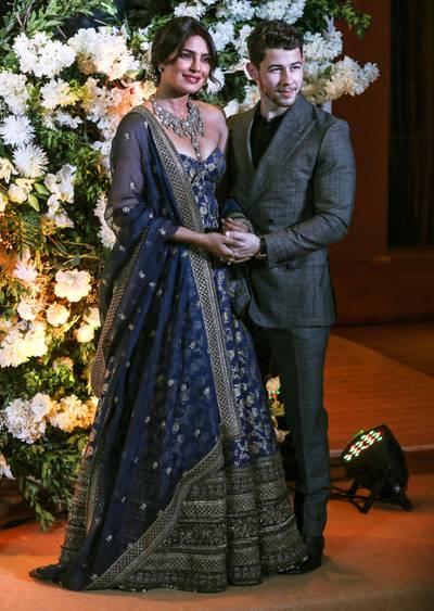 epa07240382 Newlyweds, Bollywood actress Priyanka Chopra (L) and US musician Nick Jonas (R) pose for photographs during a reception in Mumbai, India, 19 December 2018.  EPA-EFE/DIVYAKANT SOLANKI