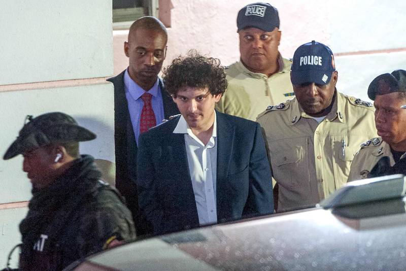 FTX co-founder Sam Bankman-Fried is led away by police officers in Nassau, the Bahamas, on Tuesday. AFP