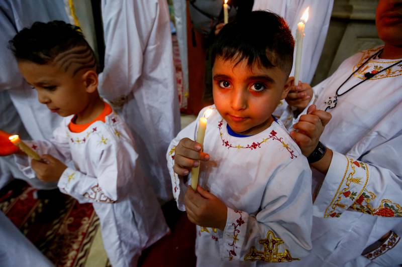 Egyptian Coptic Orthodox Christian deacon children carry candles during the Easter midnight mass in the Samaan el-Kharaz Monastery in the Mokattam Mountain area of Cairo, Egypt April 23, 2022.  REUTERS / Amr Abdallah Dalsh