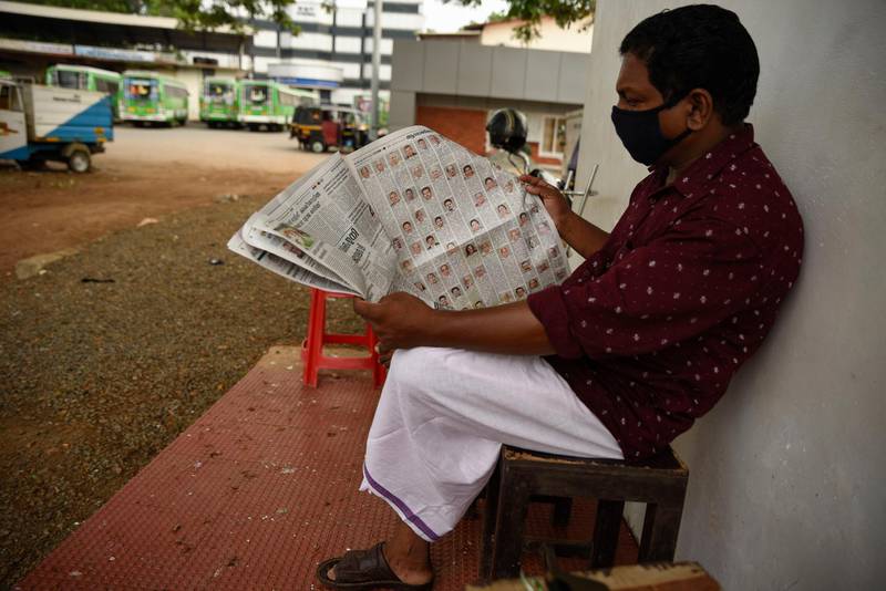 A man wearing a mask reads a newspaper at a bus terminus that has been shut down for more than a month as part of measures to curb the spread of the Covid-19 pandemic in Kochi, Kerala. AP Photo