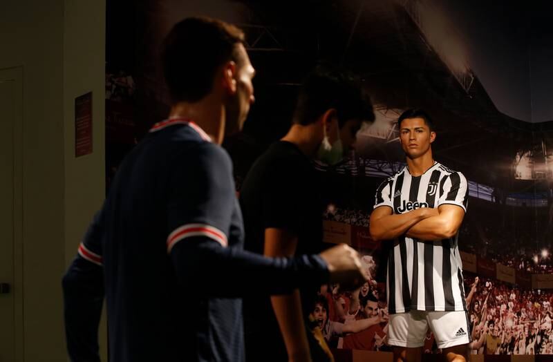 Visitors walk past the wax figures of Cristiano Ronaldo and Lionel Messi at the Madame Tussauds wax museum in Dubai on October 18, 2021. EPA