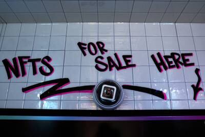 A sign saying 'NFT for sale here' in a small storefront that hosts digital art-collecting platform Neon's first in-person non-fungible token vending machine in New York City. Reuters