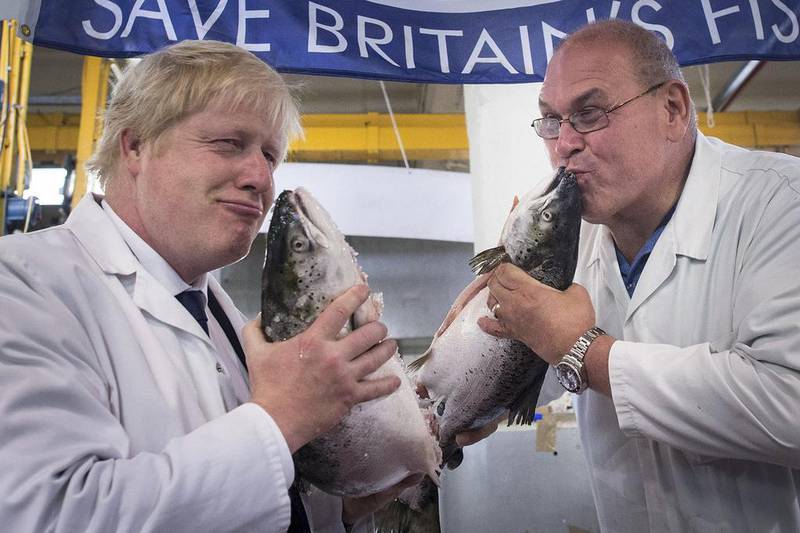Brexit campaigner Boris Johnson played the clown with a fish market porter and a couple of salmon. Stefan Rousseau / PA via AP