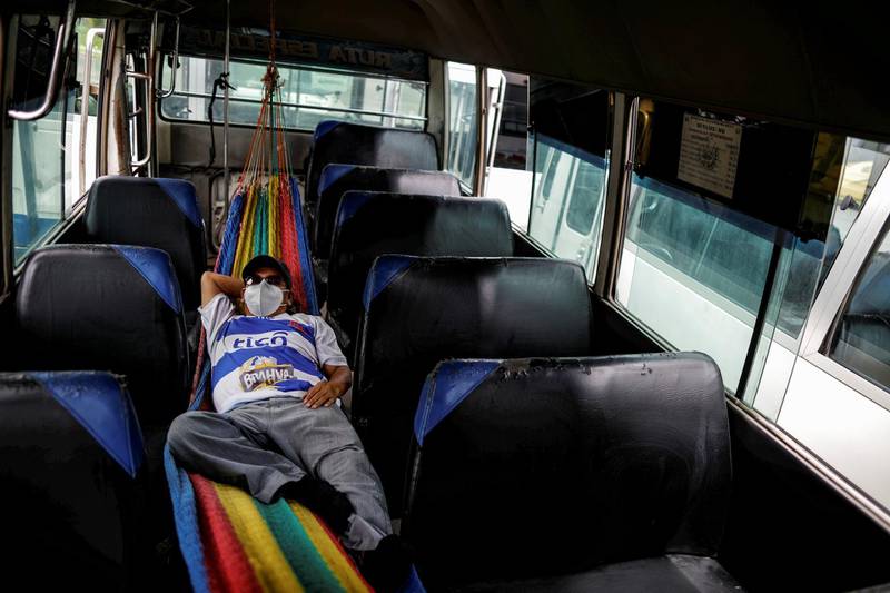 A bus driver rests between trips to transport health workers, after El Salvador's President Nayib Bukele postponed the second phase of reopening as the coronavirus disease outbreak continues, in San Salvador, El Salvador. Reuters