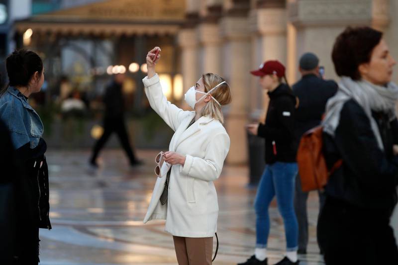 A woman wearing mask takes a selfie in Milan on Sunday. AP