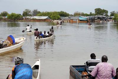 FILE PHOTO: People use canoes to cross flood waters in the town of Pibor, Boma state, South Sudan, December 11, 2019. REUTERS/Andreea Campeanu/File Photo