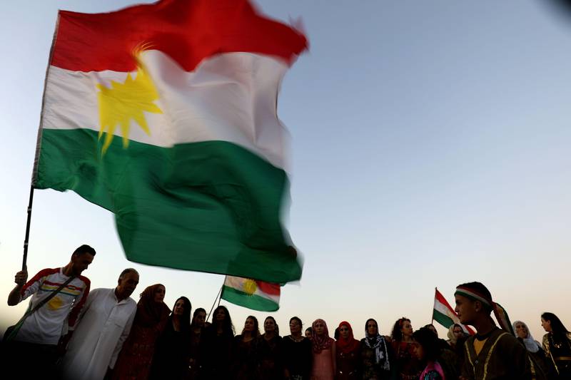 TOPSHOT - Syrian Kurds wave the Kurdish flag, in the northeastern Syrian city of Qamishli on September 27, 2017, during a gathering in support of the independence referendum in Iraq's autonomous northern Kurdish region.
Iraq's Kurds announced a massive "yes" vote for independence following a referendum that has incensed Baghdad and sparked international concern. / AFP PHOTO / DELIL SOULEIMAN