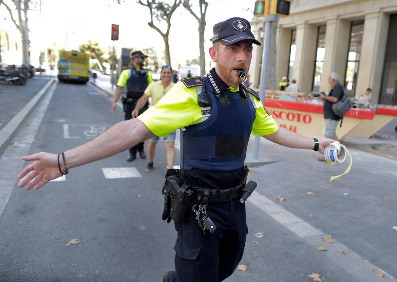 A police officer cordons off a street in Barcelona, Spain. Police in the northern Spanish city of Barcelona say a white van has jumped the sidewalk in the city's historic Las Ramblas district, killing several people. Manu Fernandez / AP Photo.