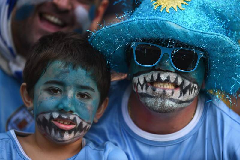 Uruguay fans smile ahead of the 2014 World Cup match against Colombia on Saturday with their faces painted in reference to Luis Suarez. Matthias Hangst / Getty Images