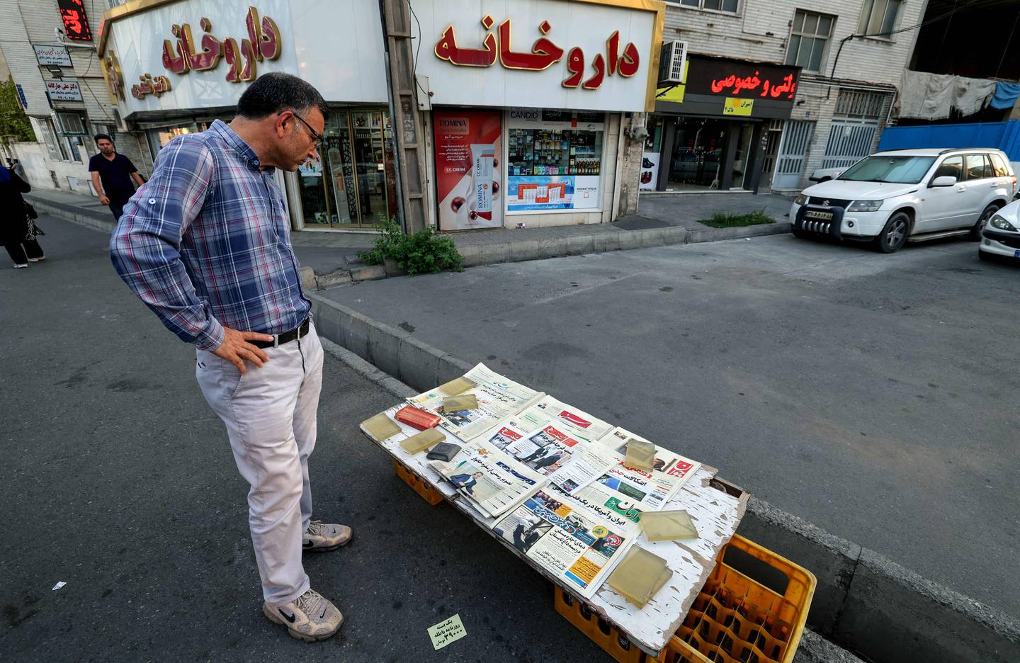 A man looks at a newspaper stall with a view of Etemad newspaper's front page bearing a title reading in Farsi "The night of the end of the JCPOA". AFP