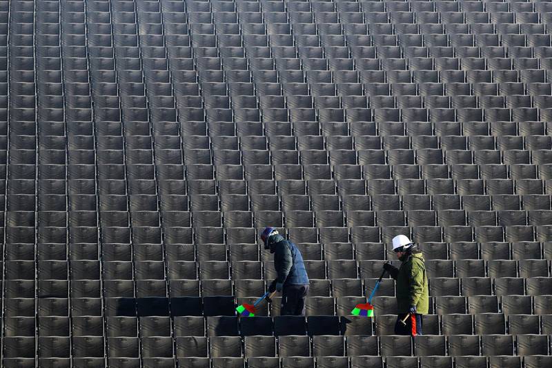 Workers clean the stands during a Snowboard slopestyle training session at the Phoenix Snow Park, which will host the Freestyle Skiing and Snowboard events of the PyeongChang 2018 Olympic Games. Fazry Ismail / EPA