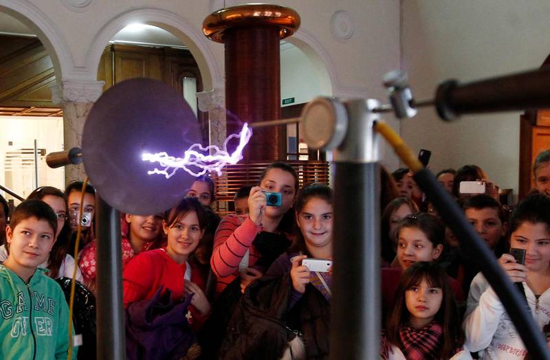 School pupils look at Nikola Tesla's coreless transformer at the Nicola Tesla Museum in Belgrade December 17, 2011. The American inventor Thomas Alva Edison, who made the incandescent light bulb viable for the mass market, also built the world's first electrical distribution system, in New York, using 'direct current' electricity. DC's disadvantage was that it couldn't carry power beyond a few blocks. His Serbia-born rival Nicola Tesla, who at one stage worked with Edison, figured out how to send 'alternating current' through transformers to enable it to step up the voltage for transmission over longer distances. Picture taken December 17, 2011.   To match Insight POWER/ACDC  REUTERS/Ivan Milutinovic (SERBIA  - Tags: EDUCATION SOCIETY SCIENCE TECHNOLOGY TRAVEL)