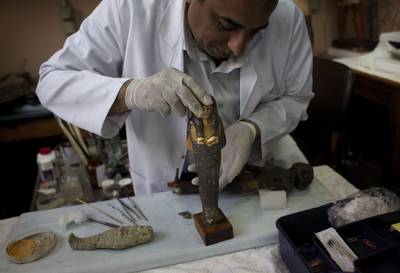 An Egyptian restorer fixes an artefact that was broken by looters at the Egyptian Museum in Cairo. The pillaging has been going in full-force since the country’s uprising in 2011. Emilio Morenatti / AP Photo