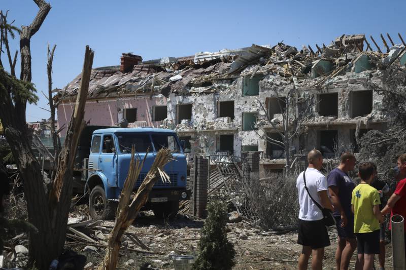 Local residents stand next to a damaged residential building in the town of Serhiivka, about 50 kilometres south-west of Odesa, Ukraine. AP