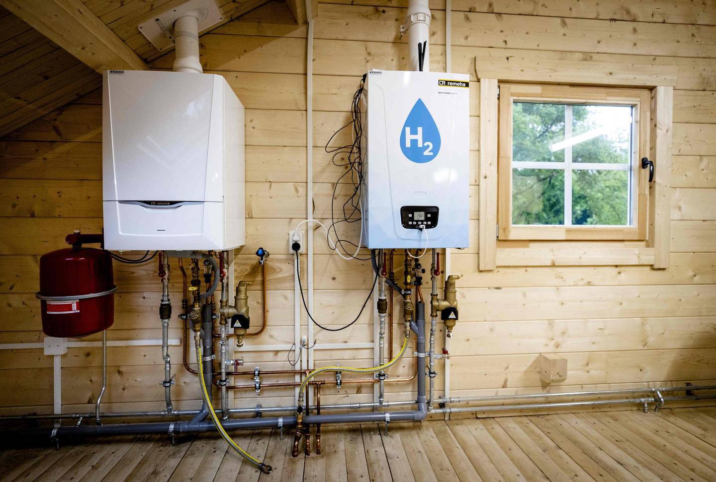 An old central heating boiler (L) and a hydrogen boiler inside the Hydrogen Experience Centre in Apeldoorn on May 27, 2021, the hydrogen house of certification body Kiwa and energy company Alliander. The house serves as a training location for technicians, who can learn how residences can be powered by hydrogen.  - Netherlands OUT
 / AFP / ANP / Sem van der Wal
