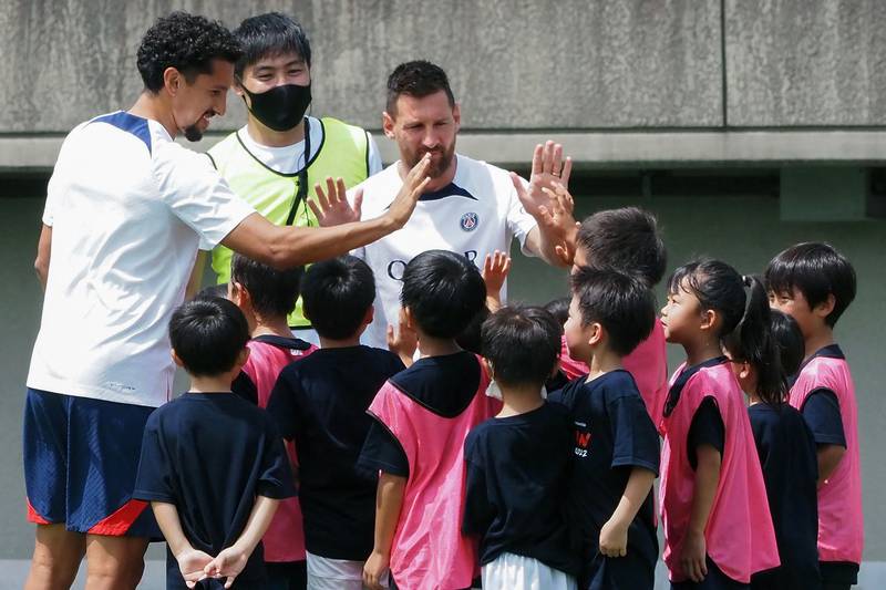 Paris Saint-Germain players Lionel Messi and Marquinhos high-five young participants while attending a soccer clinic at a stadium in Tokyo on July 18, 2022, as a part of the team’s pre-season summer tour of Japan. AFP
